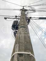 Cement pole with many electric wires.
