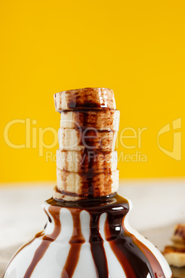 Banana slices in a little bowl with liquid chocolate.