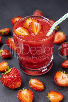 Strawberry in fresh smoothie on black table