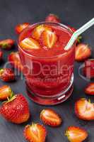 Strawberry in fresh smoothie on black table
