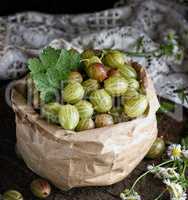 green gooseberries in a paper bag on a wooden board