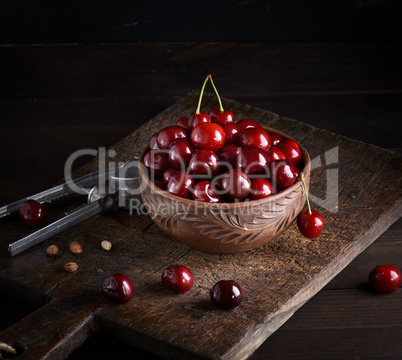 red ripe fresh cherry in a brown ceramic bowl
