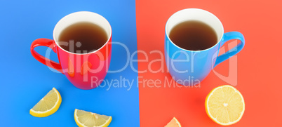 Red and blue cups with tea on a red and blue background. Wide ph