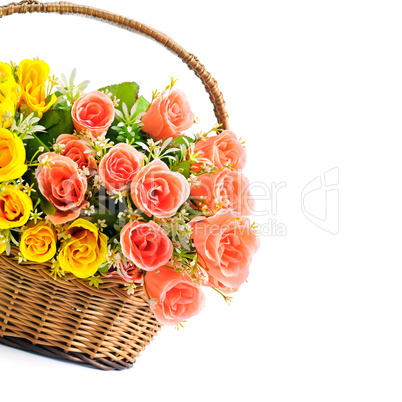 Silk red and yellow roses in a basket isolated on white backgrou