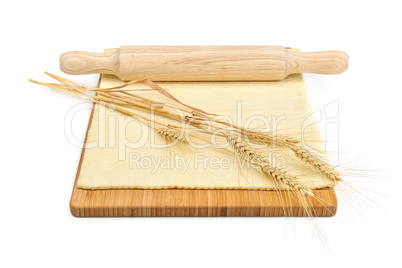 Wheat ears, rolled dough and rolling pin isolated on white backg