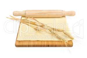 Wheat ears, rolled dough and rolling pin isolated on white backg