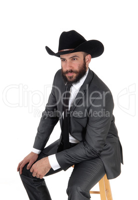 A portrait image of a man in a suit and cowboy hat