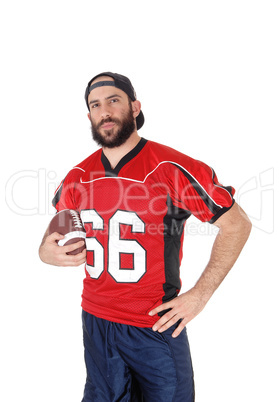 Young football player standing in closeup with his football