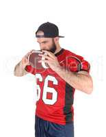 Football player holding his ball on his mouth thinking