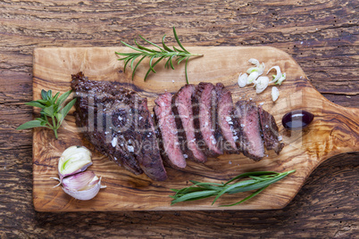 Scheiben von einem gegrillten Steak auf Holz