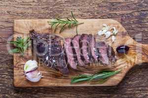 Scheiben von einem gegrillten Steak auf Holz