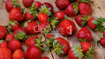Fresh strawberries spinning on wooden table