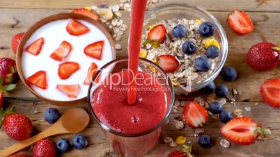 Strawberry smoothie flowing in glass for breakfast
