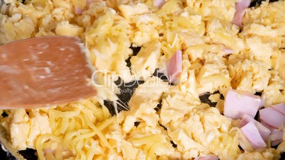 Cooking omelette with cheese and ham