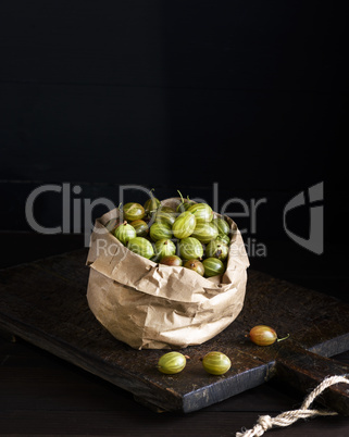 ripe green gooseberry in brown paper bag on a wooden board