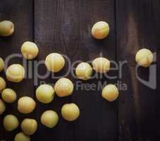 scattered ripe yellow apricots on a brown wooden table