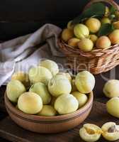 ripe apricots in a wooden bowl on a brown table