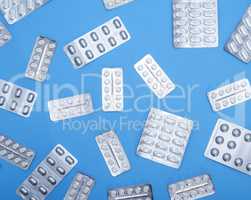 different white tablets in a package are scattered o