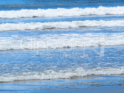 Sparkling white waves in blue sea.