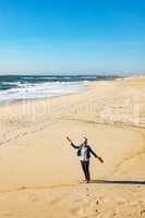 Woman is walking on the sandy beach