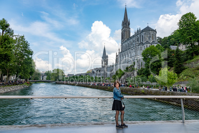 Woman in front of pilgrimage church in Lourdes