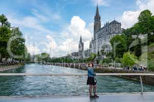 Woman in front of pilgrimage church in Lourdes