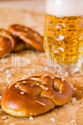 Closeup of salty cooked pretzel and lager beer