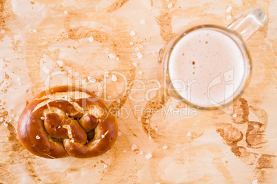 Salty cooked pretzel and lager beer seen from above