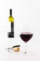 Glass of red wine and bottle on background