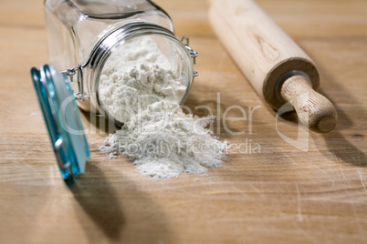 Flour in glass jar with rolling pin