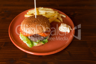 Hamburger salad and tomatoes with fried potatoes on a table