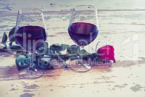 Two glasses of wine and a red rose