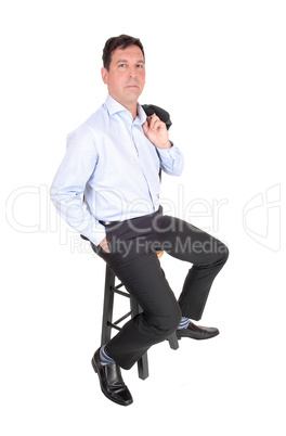 A business man sitting with his jacked over shoulder