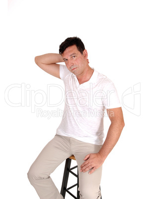 Serious looking man sitting with hand on neck