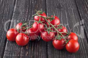 Branches cherry tomatoes on wooden table