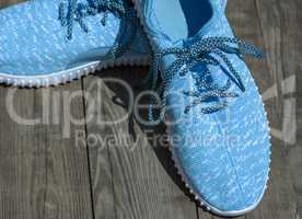 pair of textile blue shoes on a gray wooden surface