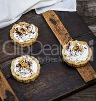 sweet cakes with white cream on a brown wooden board