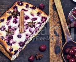 baked pie from cottage cheese and cherry berries on a brown boar