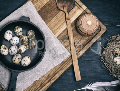 raw quail eggs in a black round frying pan