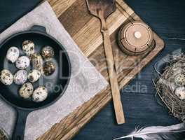raw quail eggs in a black round frying pan