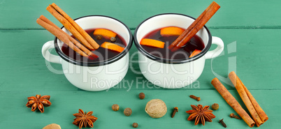 Hot red mulled wine on wooden background with christmas spices,