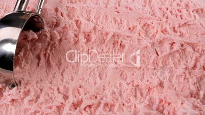Strawberry ice cream scooped out of container