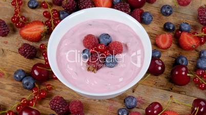 Forest fruits yogurt rotating on table full of fruits