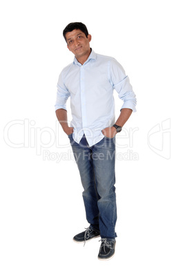 Relaxed Indian man standing in jeans and sneakers