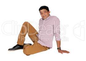 Relaxed East Indian man sitting on floor