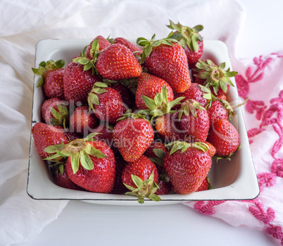 ripe red strawberry in a white iron plate