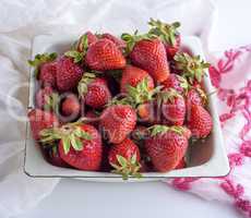 ripe red strawberry in a white iron plate
