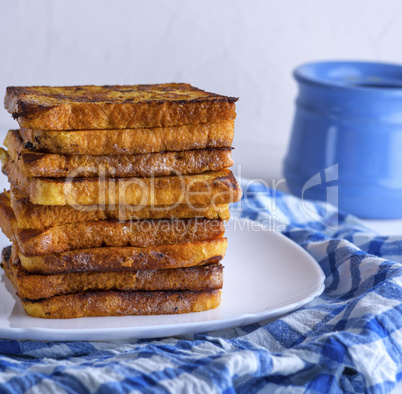 fried pieces of square white bread on a white ceramic plate
