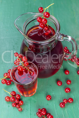 Red currant juice in glass with fruits