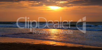 Beach of the ocean and golden sun rise. Wide photo.